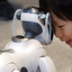 A boy playing with Sony’s AIBO ERS-7 during AIBO’s 5th anniversary exhibition held in Tokyo, Japan on May 2004.